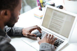 A young man typing on his laptop